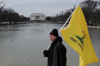 A man holds a flag during a march in opposition to COVID-19 mandates on the National Mall in Washington, DC, on January 23, 2022.