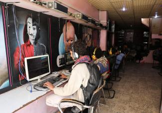 People use computers at an internet cafe after internet services were restored following a four-day outage in Sanaa, Yemen January 25, 2022.