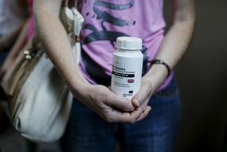 An activist of the All-Ukrainian Network of People Living With HIV/AIDS, a non-governmental group, holds an empty package of the drug Aluvia, as she takes part in a rally in front of the Ukrainian cabinet of ministers building in Kiev, Ukraine, July 1, 2015. 