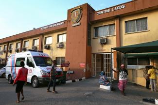 An ambulance and people are seen standing in front of a hospital in Lagos, Nigeria