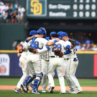 Seattle Mariners infielders hug and dance as they celebrate beating the San Diego Padres 6-1, at T-Mobile Park, in Seattle, Washington, on September 14, 2022.