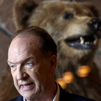 David Malpass, president of the World Bank Group, and a stuffed grizzly bear at Teton National Park, where financial leaders gathered for the Jackson Hole Economic Symposium, near Jackson, Wyoming, on August 26, 2022. 
