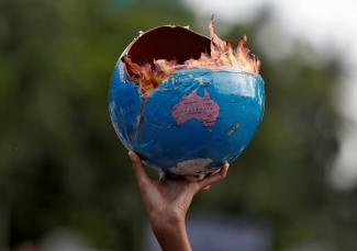A protestor participating in a "Fridays for Future" march calling for urgent measures to combat climate change holds a globe designed to look like it is on fire, in Mumbai, India, on September 27, 2019. Photo by REUTERS/Francis Mascarenhas