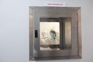 A production scientist puts a sample in the pass through hatch, during a visit by representatives of the Medicines Patent Pool, France and other European Union member states, at the Afrigen Biologics' site in Cape Town, South Africa, February 3, 2022. 