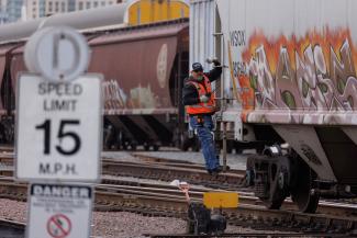 A railway worker helps load railcars onto a train in San Diego, California, U.S., November 30, 2022. 