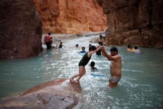 People swim in a river in the Valley of al-Zara, which flows into the Dead Sea, in Jordan, November 5, 2016. 