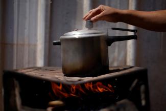 Luciana Messias dos Santos, 29, cooks using firewood outside her home in the Estrutural favela in Brasilia, Brazil, August 31, 2022. "People say Bolsonaro is helping. But he gives and then takes it away. It was much better with Lula," said Luciana. In her wooden shack in Estrutural, Brasilia's largest favela, she has had to adapt her stove to cook with wood as fuel because gas is too expensive. REUTERS/Adriano Machado 