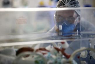 A nurse takes care of a newborn baby in an incubator at the intensive care unit of the Nossa Senhora da Conceicao hospital, after the baby's mother was tested positive for coronavirus disease (COVID-19) in Porto Alegre, Brazil, March 11, 2021.