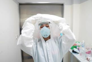 A doctor takes off her personal protection equipment after treating a patient suffering from COVID-19, in the Intensive Care Unit ICU, at the King Chulalongkorn Memorial Hospital in Bangkok, Thailand.
