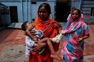 A woman carries her daughter for treatment at a government hospital during a strike by doctors demanding security after the recent assaults on doctors by the patients' relatives, in Kolkata, India, on June 14, 2019.