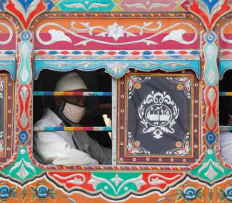 A passenger wearing a protective face mask is seen from the window of a bus  in Karachi, Pakistan, on June 3, 2020. 