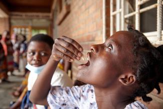 Eliza Tangwe, eighteen, takes a dose of oral cholera vaccine at a health centre in response to the latest cholera outbreak in Blantyre, Malawi, on November 16, 2022.