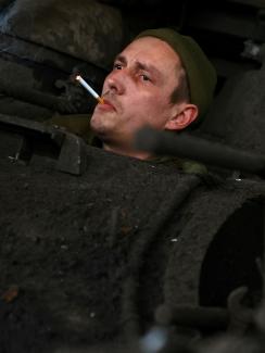 A member of the Ukrainian tank unit crew, call sign "Tyagach," waits for mechanics to maintain their tank after returning from a mission at the frontline, in Bakhmut, Ukraine, on April 3, 2023.