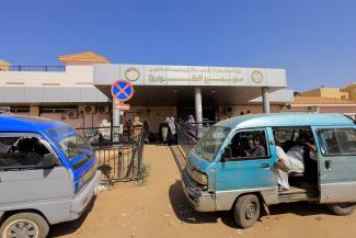 People wait at the gate of the Ibrahim Malik Hospital in Khartoum, Sudan, on February 21, 2022.