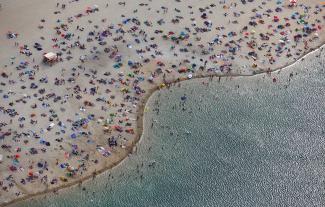 An aerial view shows people at a beach on the shores of lake Silbersee (Silver Lake) during a long-lasting heatwave over central Europe in Haltern, Germany, on August 4, 2018. 