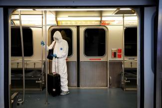 A woman wears personal protective equipment as she rides the airtrain at John F. Kennedy International Airport in New York City, on March 20, 2020.