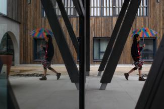 Alzheimer’s patient Laetitia, thirty-nine, is reflected in a mirror as she walks with an umbrella at the Village Landais Alzheimer site in Dax, France, on September 24, 2020. 