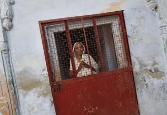 A widow poses at the entrance of a staircase at the Meera Sahavagini ashram in the pilgrimage town of Vrindavan in the northern Indian state of Uttar Pradesh March 6, 2013.