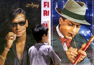 A boy looks at a posters of Bollywood stars smoking cigarettes during An anti-tobacco demonstration in Bombay, India.