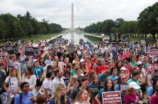 A crowd of anti-abortion demonstrators listen as former U.S. Vice President Mike Pence (not pictured) speaks at the "National Celebrate Life Day Rally" in Washington, DC, with the Washington Monument in the background.