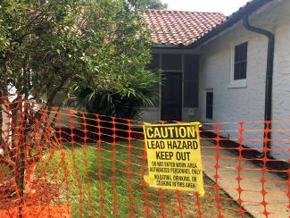 A warning sign about lead is seen displayed outside a home. 