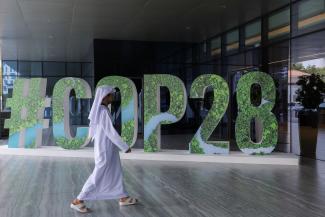 A man walks past a COP28 sign.