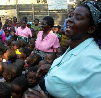 Community worker Grace Angoni sings with children at the Chifundo orphan care center in Blantyre.