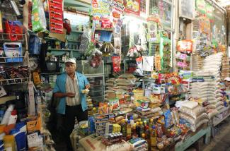 A man sells groceries at his store in a market,