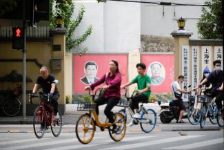 People pass by portraits of Chinese President Xi Jinping and late Chinese chairman Mao Zedong.