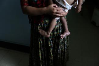 A woman holds her holds her one-year-old son at the Maternal and Child Care Center. 