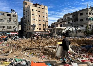 Palestinians inspect damages following an Israeli raid at Kamal Adwan hospital.