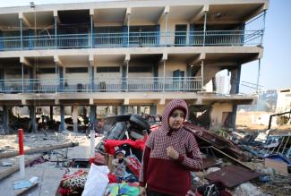 Palestinians walk at the damaged UNRWA school, following an Israeli ground operation.