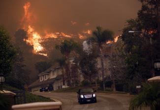 A car drives away from the Colby Fire in hills above Glendora, California, on January 16, 2014.