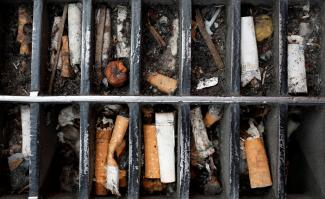 Discarded cigarette butts are seen lodged in a sidewalk grating in Manhattan.