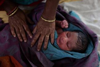 A nurse takes care of a newborn baby after the birth at a hospital in Kishanganj district, Bihar, India, March 20, 2023. India's fertility rate, fell to 2.0 in 2019-2021, but state health officials estimate Kishanganj's fertility rate at 4.8 or 4.9, creating population growth that the state is trying to curb with the distribution of condoms and birth control pills. REUTERS/Anushree Fadnavis
