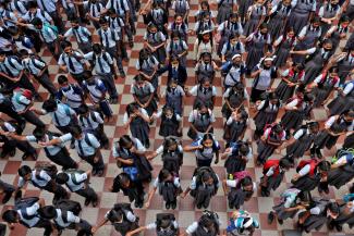 Children assemble for morning prayers after schools reopen with full capacity following their closure due to COVID-19.