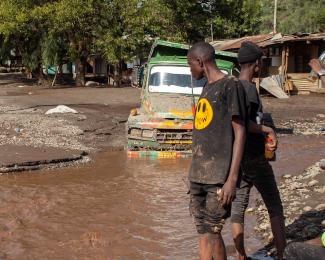 A person looks at a road that was washed away in a flash flood