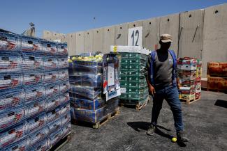 A man walks next to humanitarian aid destined for the Gaza Strip, amid the ongoing conflict in Gaza between Israel and Hamas.