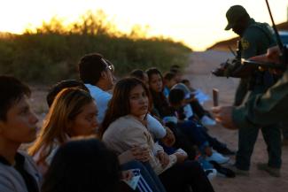 Migrants are detained by U.S. Border Patrol agents after crossing into the United States from Mexico.