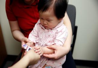 One-year-old Bella Huang gets some stickers after receiving several vaccines at the International Community Health Services clinic.