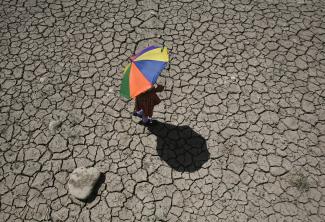 A schoolgirl crosses a dry pond on the outskirts of Jammu April 23, 2010. 