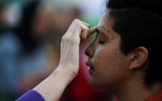 A person gets their face painted to take part in a rally in favor of legalizing abortion.