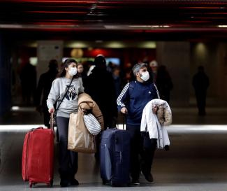People wearing masks are seen at a railway station.