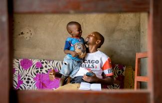 Manigaba Eric, plays with his son in their home after returning from the mpox treatment center.