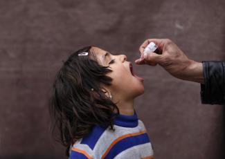 An Afghan child receives polio vaccination drops during an anti-polio campaign.
