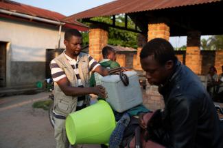 A local health official places a box containing samples onto a motorcycle in front of the Yalolia health centre, in Yakusu, Tshopo, Democratic Republic of Congo, on October 3, 2022. 
