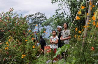 People watch as relief materials are loaded onto a helicopter to be delivered to inaccessible areas after flash floods caused by a lake burst, in Sikkim, India, on October 9, 2023.