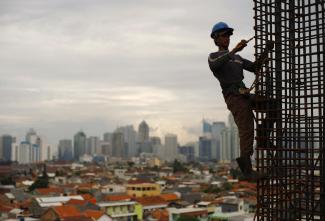 A worker stands on steel rods at a construction site, Jakarta, Indonesia, on February 2, 2010. 