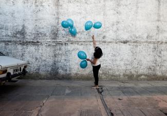 Michell, granddaughter of Rosalia Reyes who was sentenced to eight years in prison after her baby died during a home childbirth, plays with balloons during the welcome party for Rosalia 