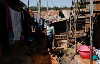 Alice Okwirry, 50, a widow living with HIV/AIDS, walks near her house, in Kianda village, Nairobi, Kenya, on February 28, 2025. 